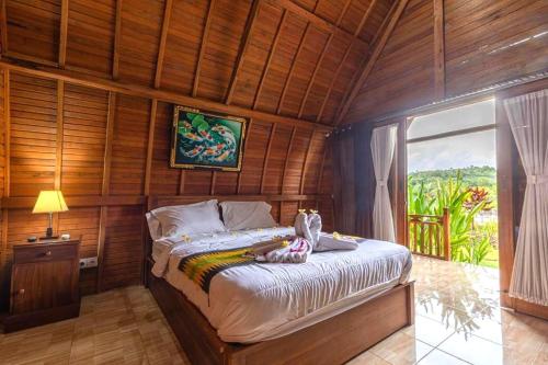 a bedroom with a bed in a wooden room at The Sweet Corn Bungalow in Nusa Penida