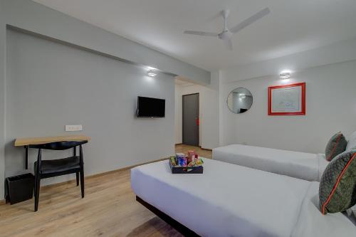 a hotel room with a bed and a desk at Super Townhouse Hadapsar in Pune