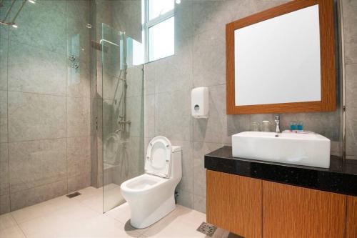 a bathroom with a toilet and a sink and a shower at Villa Chee in Sekincan