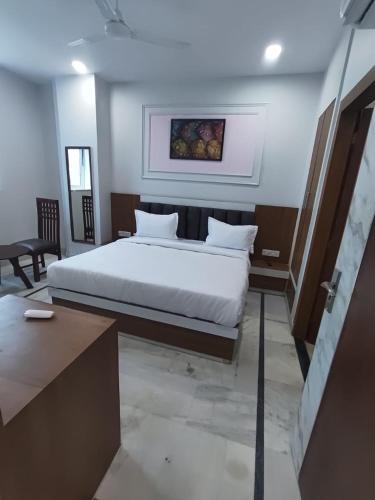 a bedroom with a white bed in a room at Hotel Roshanee in Jaipur