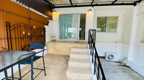 a balcony with stairs and a table and a window at Cozy 3 Bedroom Townhouse Phuket Town - Sleeps 7 in Ban Khok Chang