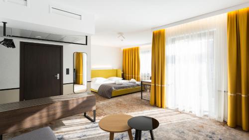 a hotel room with a bed and yellow curtains at Qubus Hotel Kraków in Kraków