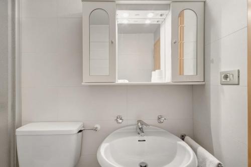 a white bathroom with a sink and a mirror at Pension Waldheim Apartments in San Giacomo