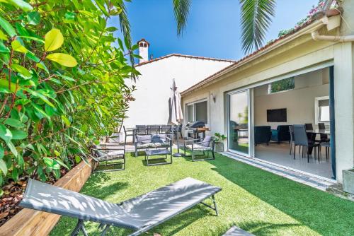 Un jardín con sillas y un patio con tv. en Valentine by Terry's Homes, en Cannes