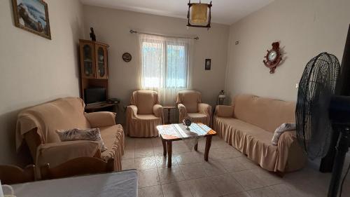 ein Wohnzimmer mit Sofa, Stühlen und einem Tisch in der Unterkunft Gerea's Holiday House in Durrës