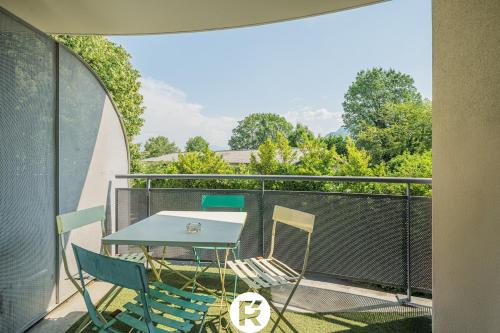a patio with a table and chairs on a balcony at R'Apparts T2 L'Echappée Douce in Sassenage