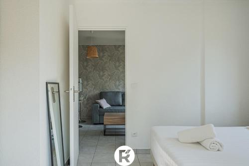 a bedroom with a bed and a living room with a couch at R'Apparts T2 L'Echappée Douce in Sassenage