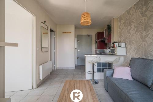 a living room with a couch and a kitchen at R'Apparts T2 L'Echappée Douce in Sassenage