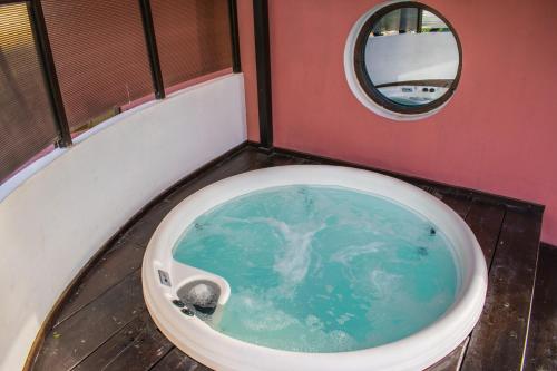 a bathroom with a tub with blue water in it at Kallisti Hotel in Potos