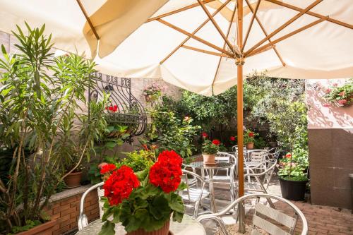 a patio with an umbrella and tables and chairs at Hotel Vittoria in Milan