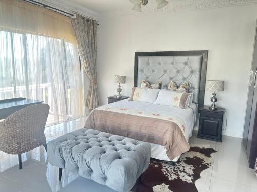 a bedroom with a bed and a large window at Mountain View Guest House in Underberg in Underberg