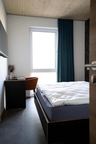 a bedroom with a large bed and a window at Motel Q in Jestetten