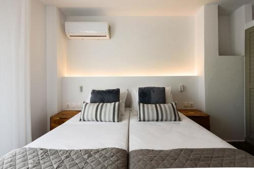 a bedroom with a large white bed with two pillows at Phaedrus Living Paros Cycladic Residences 6 in Kampos Paros