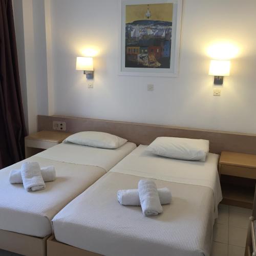 two beds in a hotel room with towels on them at Blue Roses in Ixia