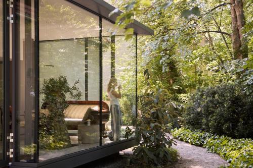 ein Glashaus mit einer Frau darin in der Unterkunft Willa Deco Sopot by Downtown Apartments in Sopot