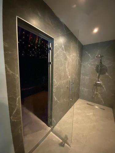 a bathroom with a shower with a glass door at Apartman Tornik Relax&Spa 2 in Zlatibor