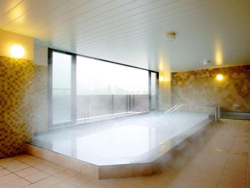 a empty room with a large window in a building at Tateyama Kokusai Hotel in Toyama