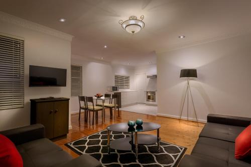 a living room with a couch and a table at Crest On Barkly Serviced Apartments in Melbourne