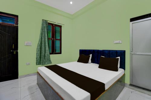 a bedroom with a bed in a room at SPOT ON Hotel The Baithak & Restaurant in Etāwah