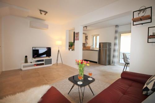 a living room with a couch and a table and a tv at Irina in Poreč