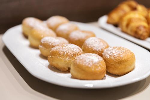 a plate of donuts with powdered sugar on it at Hotel Mary Rose in Lazise
