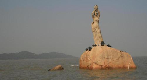 a rock with a statue on it in the water at Borrman Hotel Zhuhai Gongbei Port Fuhuali Light Rail in Zhuhai