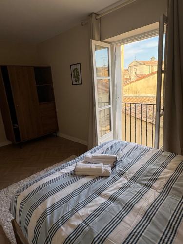 a bedroom with a bed with two towels on it at La Petite Étoile d'Avignon in Avignon