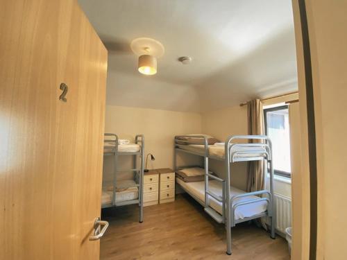 a room with three bunk beds and a door at Slieve Foy Apartment in Carlingford