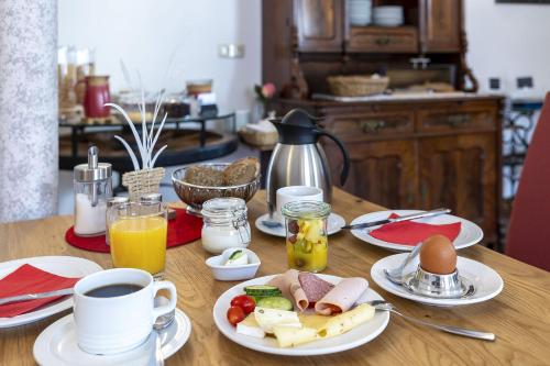 a table with plates of food and a cup of coffee at Bruckmayers Gästehaus in Pottenstein