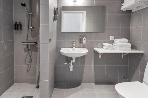 a bathroom with a sink and a shower and a toilet at Katrinelund Gästgiveri & Sjökrog in Stora Mellösa
