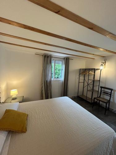 a bedroom with a bed and a chair and a window at Pé na Terra Terraço in Reguengos de Monsaraz