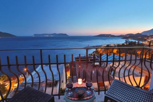a balcony with a table and chairs and the ocean at Hotel Begonvil in Kas