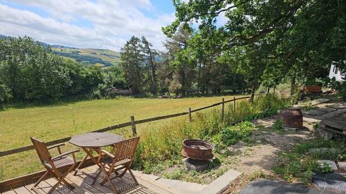 a patio with a table and chairs and a fence at Cosy Caravan Walkers Ramblers Fishermen Cyclists in Abermule