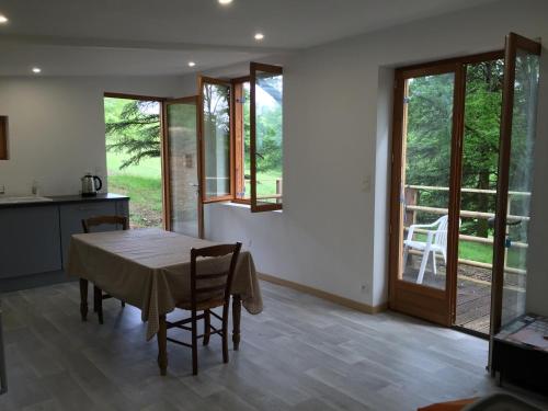 une cuisine et une salle à manger avec une table et des chaises dans l'établissement Le Chalet des Perrieres, à Saint-Raphaël