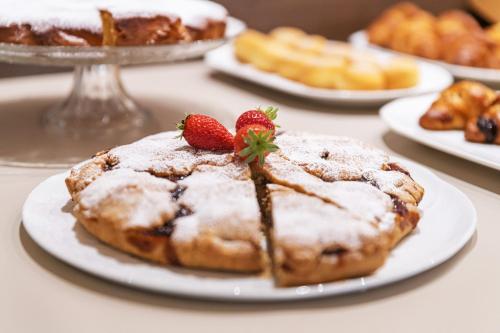 a table with plates of pastries with strawberries on them at Hotel Mary Rose in Lazise