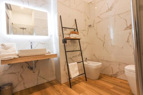 a bathroom with a sink and a mirror and a toilet at 49 Downtown Pompeii in Pompei