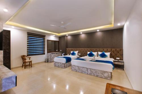 a bedroom with two beds with blue pillows at VERTTU Horizon Delhi Airport Free Airport Pick Up in New Delhi
