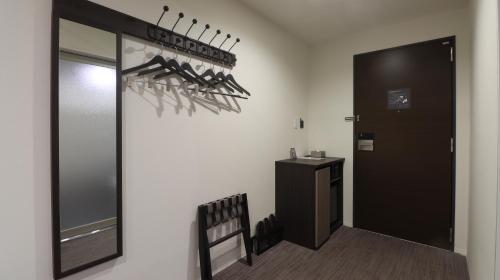 a room with a hallway with a mirror and a chair at Wander Kyoto Nanajo in Kyoto