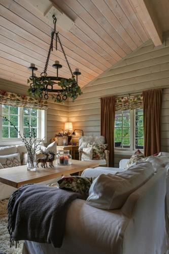 a living room with two beds and a chandelier at Cabin Between Mountain And Forest in Lampeland