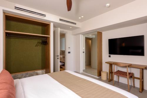 a bedroom with a bed and a desk and a television at Blue Sea Beach Affiliated By Melia in Stalida