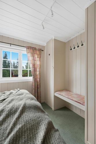 a bedroom with a bed and a window at Cabin Between Mountain And Forest in Lampeland