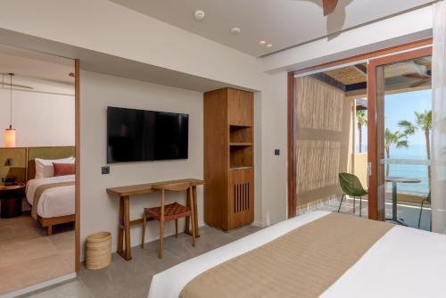 a hotel room with a bed and a tv and a bedroom at Blue Sea Beach Affiliated By Melia in Stalida