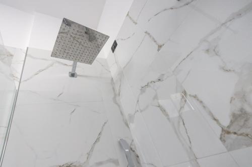 a white marble bathroom with a sign on the wall at 49 Downtown Pompeii in Pompei