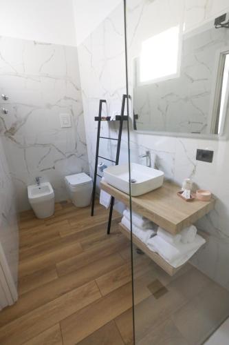 a bathroom with a sink and a toilet and a mirror at 49 Downtown Pompeii in Pompei