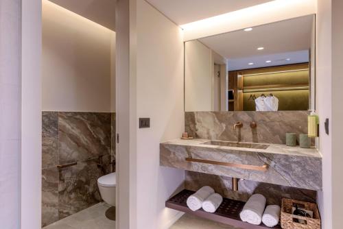 a bathroom with a sink and a toilet at Blue Sea Beach Affiliated By Melia in Stalida