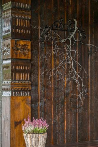 a wooden door with a vase with flowers in it at Cabin Between Mountain And Forest in Lampeland