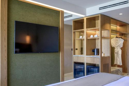 a bedroom with a large flat screen tv on a wall at Blue Sea Beach Affiliated By Melia in Stalida