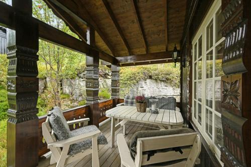 a screened in porch with a table and chairs at Cabin Between Mountain And Forest in Lampeland