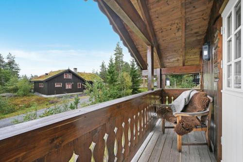 a porch with a view of a house at Cabin Between Mountain And Forest in Lampeland