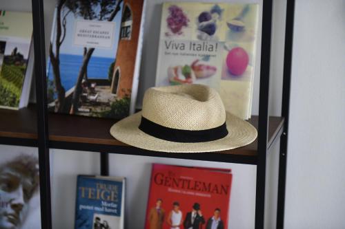 a hat is sitting on a shelf with pictures at Villa Scala Menaggio in Menaggio